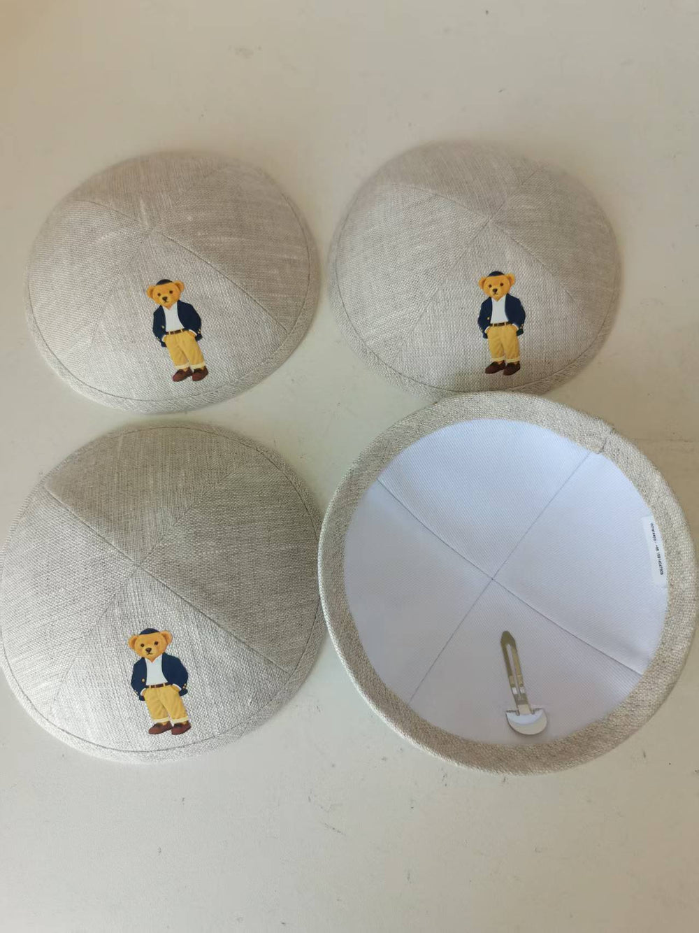 Beige kippahs with a colorful illustration